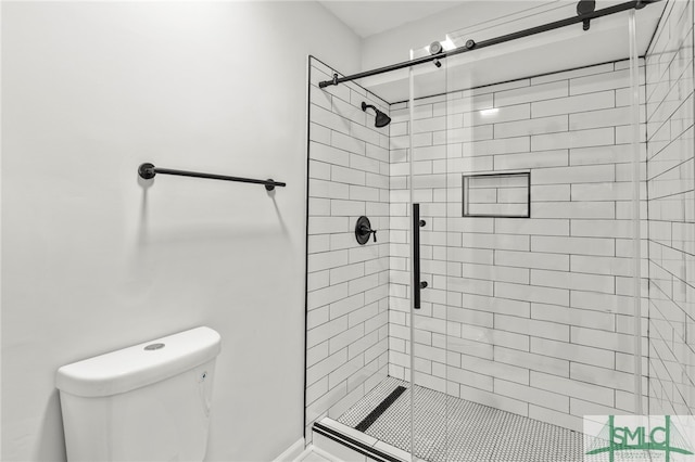 bathroom featuring tiled shower and toilet