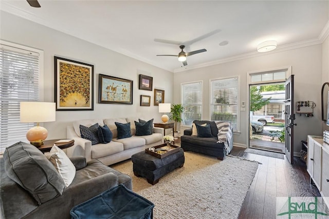 living area with ornamental molding, a ceiling fan, baseboards, and wood finished floors