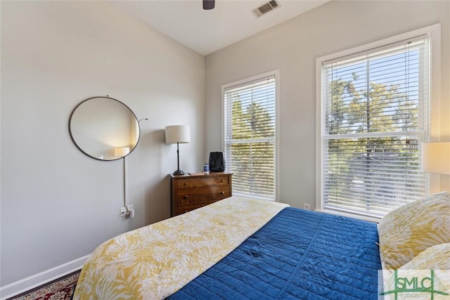 bedroom with ceiling fan, visible vents, and baseboards