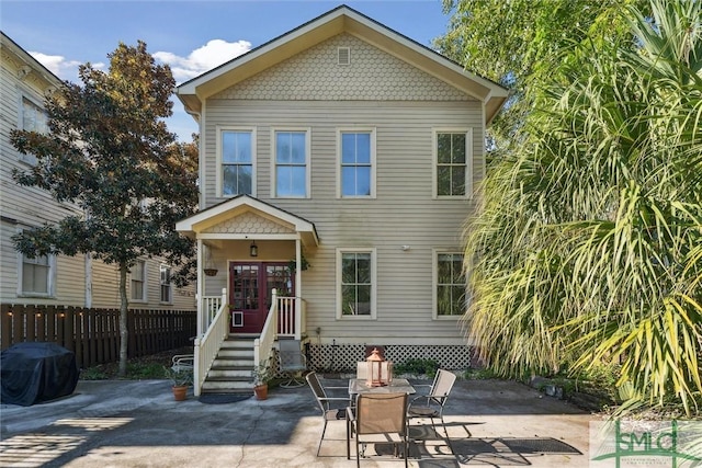 view of front facade featuring a patio area, fence, and a fire pit