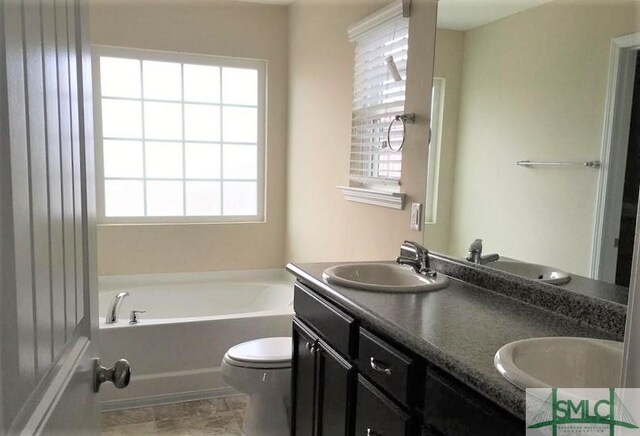 bathroom with toilet, a bathing tub, and vanity