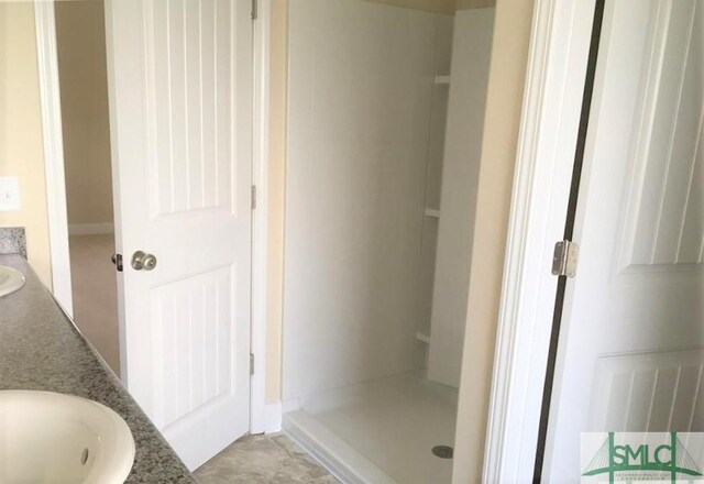 bathroom with vanity and a shower