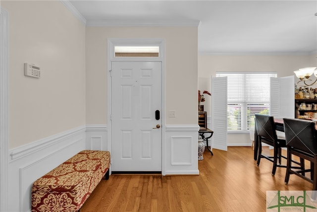 entryway featuring hardwood / wood-style floors, an inviting chandelier, and crown molding