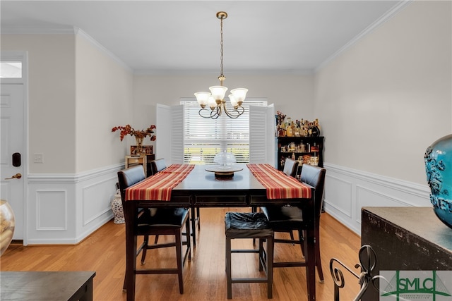 dining room featuring an inviting chandelier, crown molding, and light hardwood / wood-style flooring