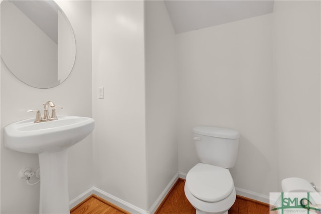 bathroom with toilet and hardwood / wood-style floors