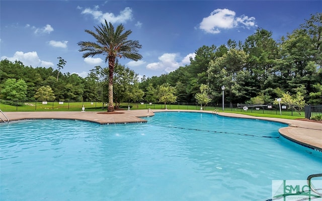 view of swimming pool with a yard