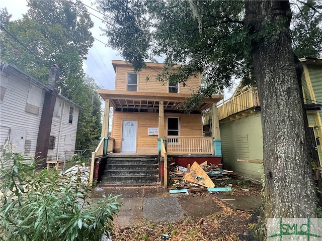 back of property featuring covered porch