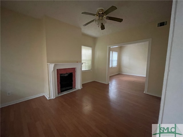 unfurnished living room featuring dark wood-type flooring, ceiling fan, and a fireplace