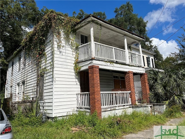 view of front facade with covered porch and a balcony