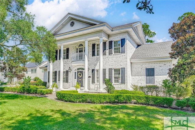 greek revival house with a balcony and a front lawn