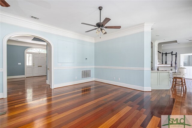 interior space with ceiling fan, dark hardwood / wood-style floors, and ornamental molding