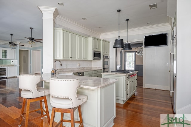 kitchen featuring dark hardwood / wood-style flooring, appliances with stainless steel finishes, a center island, kitchen peninsula, and ceiling fan