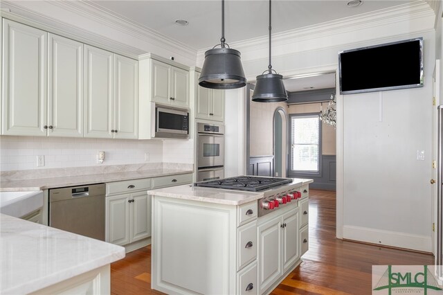 kitchen featuring a kitchen island, stainless steel appliances, light stone countertops, and wood-type flooring