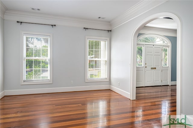 entryway with dark wood-type flooring, plenty of natural light, and ornamental molding