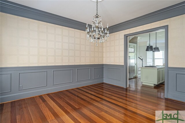 unfurnished room with crown molding, dark hardwood / wood-style floors, and a notable chandelier