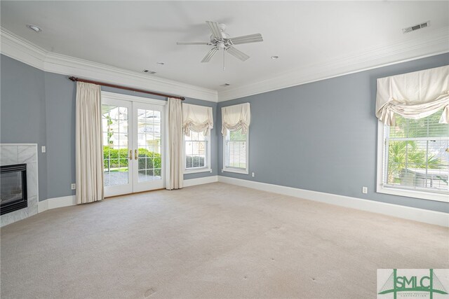 unfurnished living room with crown molding, ceiling fan, french doors, and a fireplace