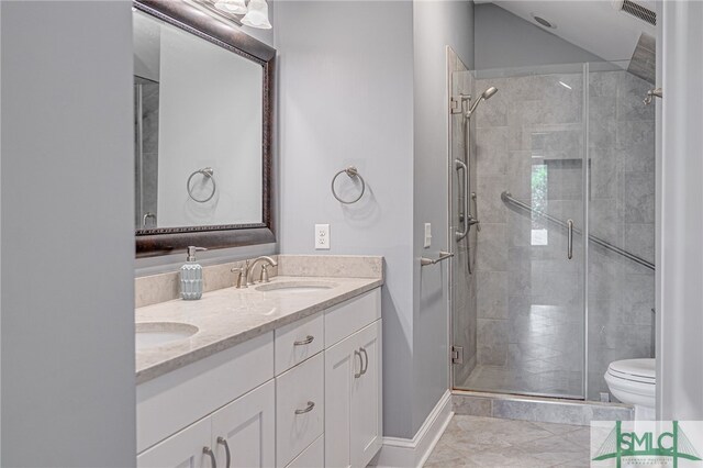 bathroom featuring vanity, toilet, tile patterned floors, and a shower with shower door