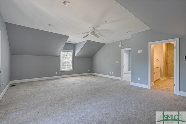 additional living space featuring ceiling fan, light carpet, and vaulted ceiling