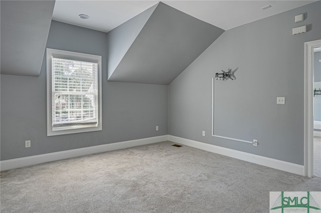 bonus room featuring lofted ceiling and light colored carpet