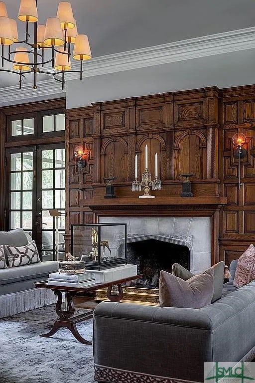 living room with a fireplace, french doors, crown molding, and a chandelier