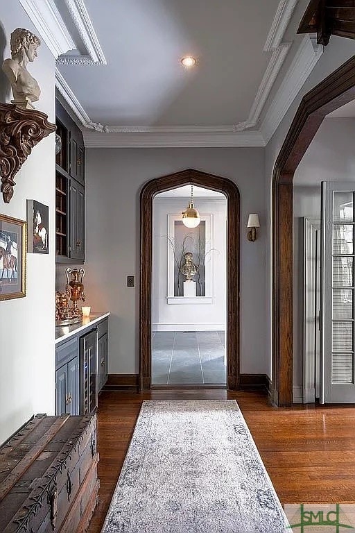 foyer entrance featuring dark hardwood / wood-style floors and crown molding