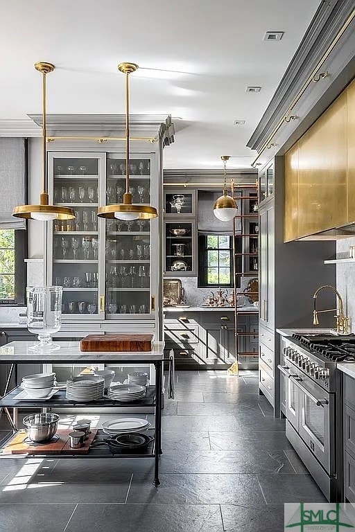 kitchen with crown molding, pendant lighting, and stainless steel range