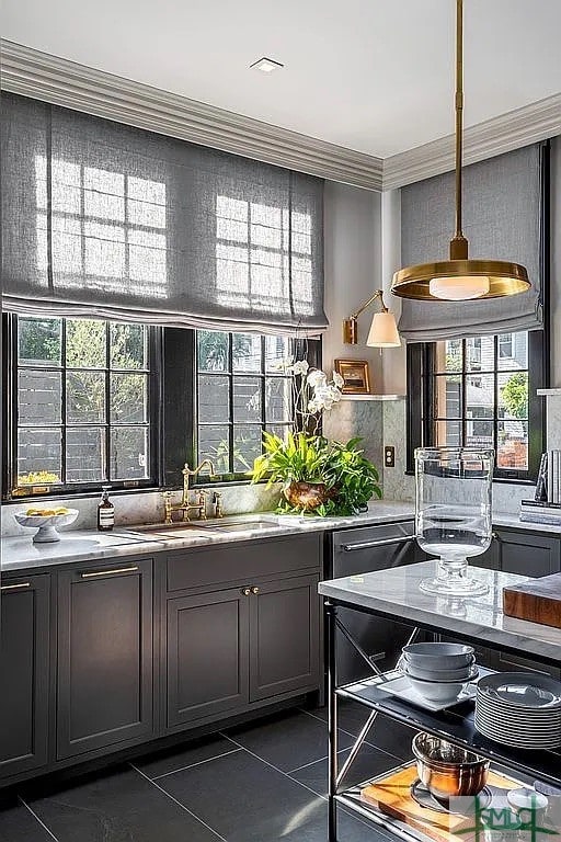 interior space with ornamental molding, backsplash, dark tile patterned floors, and sink