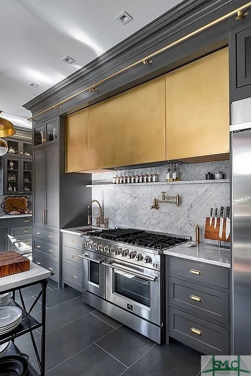 kitchen featuring high end appliances, tasteful backsplash, and ornamental molding