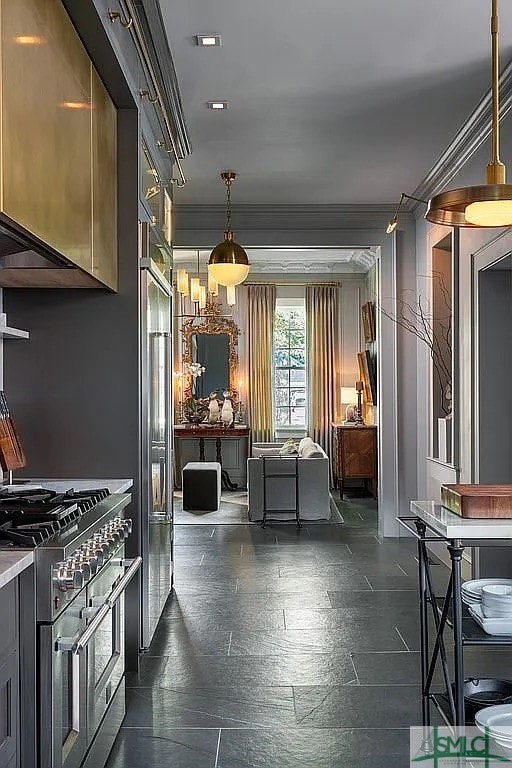 kitchen featuring decorative light fixtures, high quality appliances, and ornamental molding