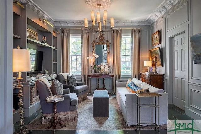 sitting room featuring plenty of natural light, ornamental molding, dark tile patterned floors, and a notable chandelier