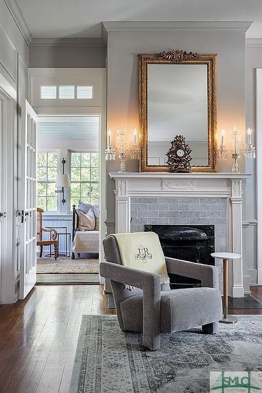 sitting room featuring wood-type flooring, a fireplace, and crown molding