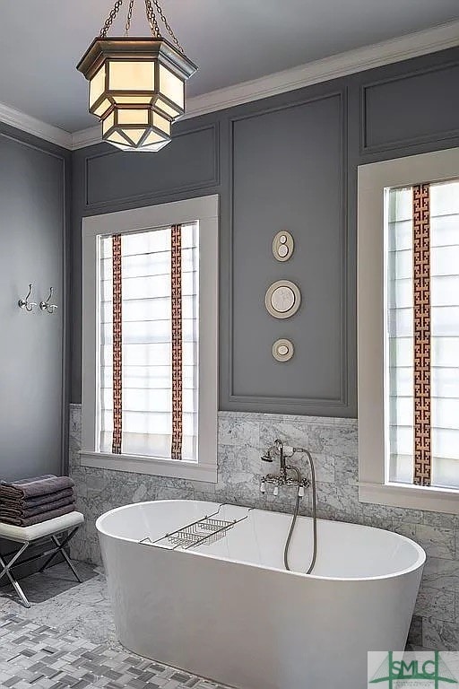 bathroom with a tub, plenty of natural light, and crown molding