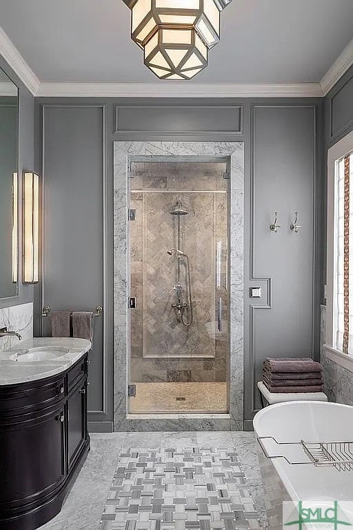 bathroom with crown molding, vanity, and independent shower and bath