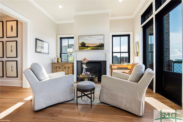 living room with ornamental molding and light hardwood / wood-style flooring