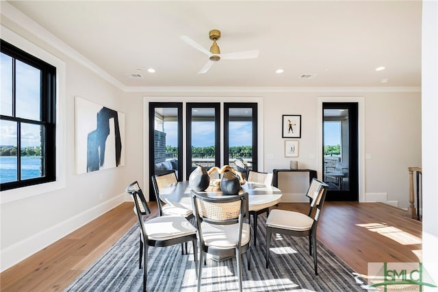 dining room with hardwood / wood-style floors, ceiling fan, and crown molding