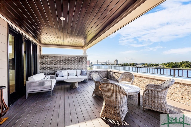 wooden deck with outdoor lounge area and a water view