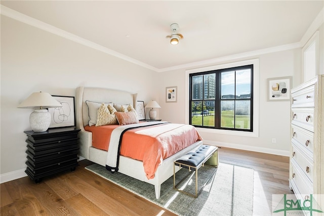 bedroom with crown molding and hardwood / wood-style floors