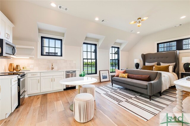 bedroom with light wood-type flooring and sink