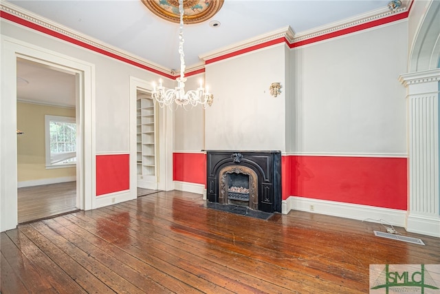 unfurnished living room with a high end fireplace, an inviting chandelier, ornamental molding, and dark hardwood / wood-style flooring