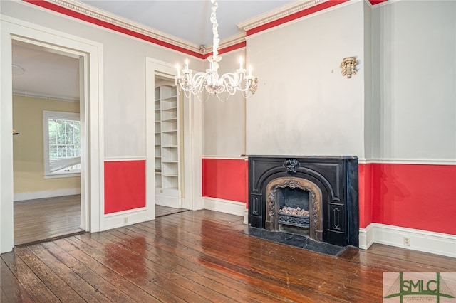 unfurnished living room with crown molding, dark hardwood / wood-style flooring, and a notable chandelier