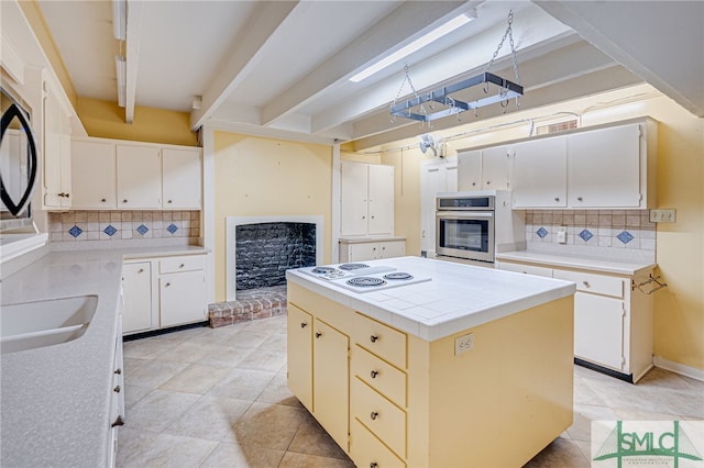 115 W Gordon St, Savannah, GA 31401 - kitchen with stainless steel oven, tasteful backsplash, white electric cooktop, and a center island