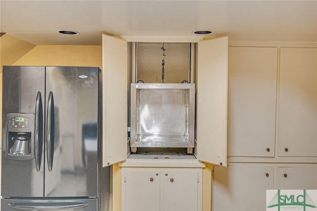 kitchen with refrigerator with ice dispenser and white cabinets