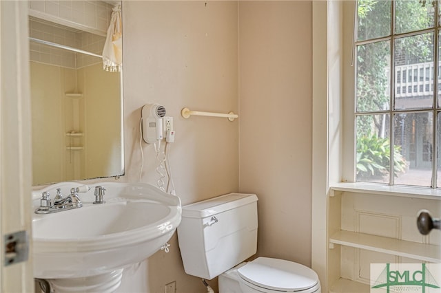 bathroom with toilet, a shower with curtain, and sink