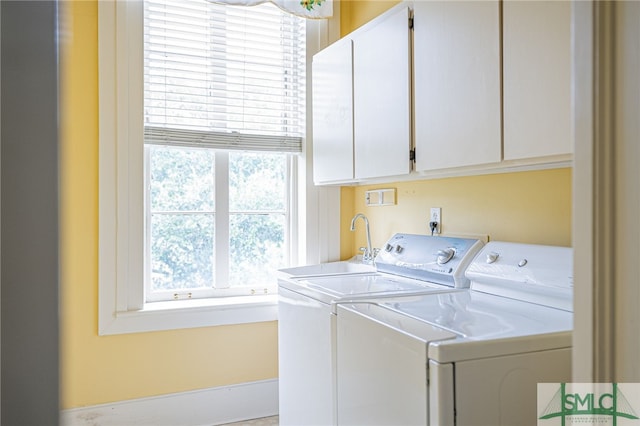 laundry area with a wealth of natural light, cabinets, and washing machine and dryer