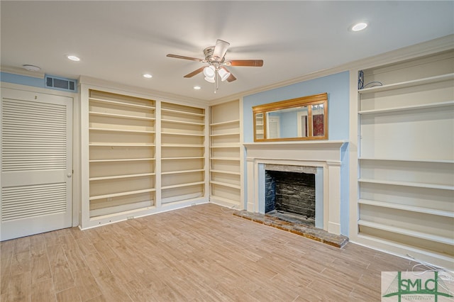 115 W Gordon St, Savannah, GA 31401 - unfurnished living room featuring a ceiling fan, built in shelves, a fireplace with raised hearth, crown molding, and wood finished floors