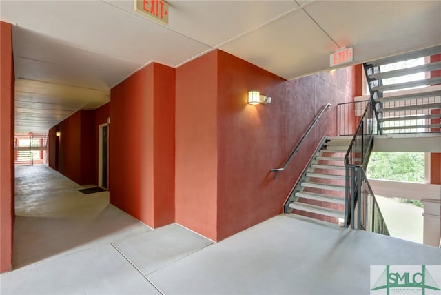 stairs with concrete flooring and plenty of natural light