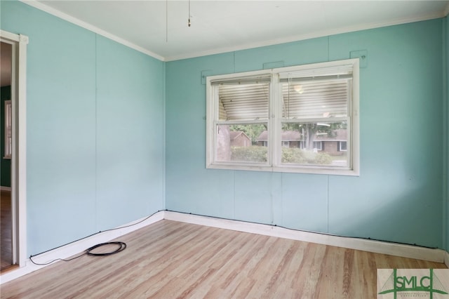 empty room with ornamental molding and light wood-type flooring