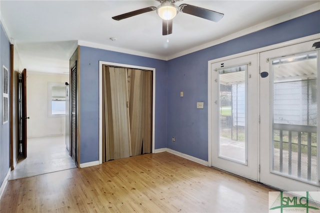 doorway to outside featuring light hardwood / wood-style floors, ornamental molding, ceiling fan, and french doors