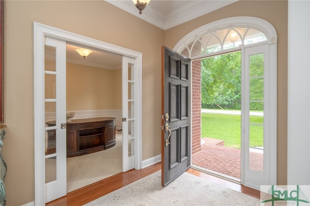 doorway to outside featuring wood-type flooring, french doors, and ornamental molding