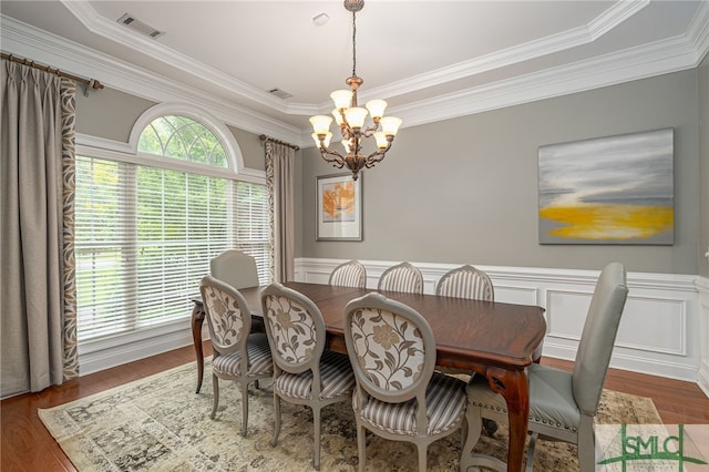 dining area with a notable chandelier, crown molding, and dark wood-type flooring